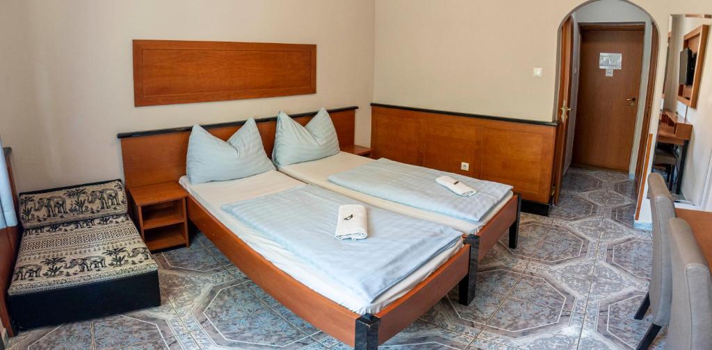 a bedroom with a bed and a chair in it at Richter Pansion in Budapest