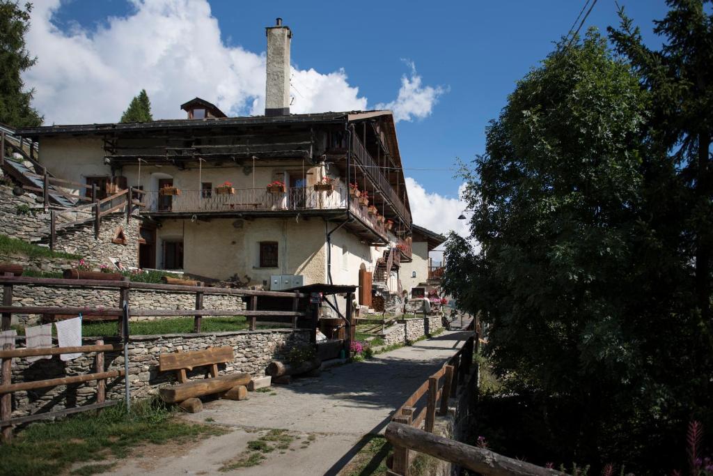 an old house with a fence in front of it at Sci e montagna vera in Pragelato