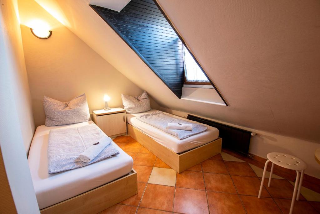 a attic room with two beds and a window at Richter Pansion in Budapest