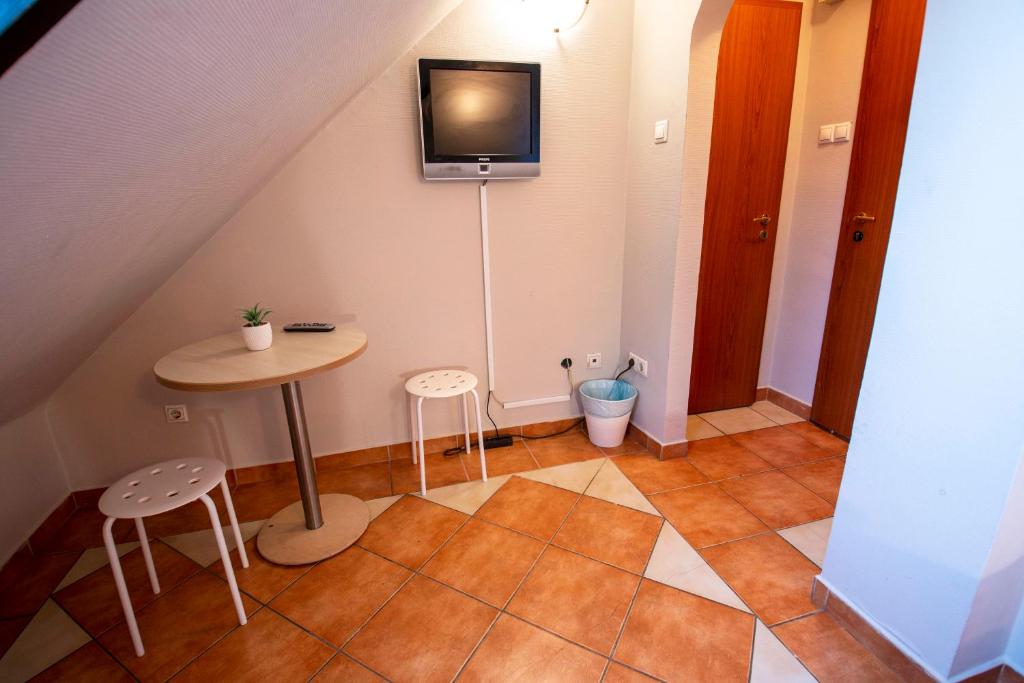a small room with a table and a tv on the wall at Richter Pansion in Budapest