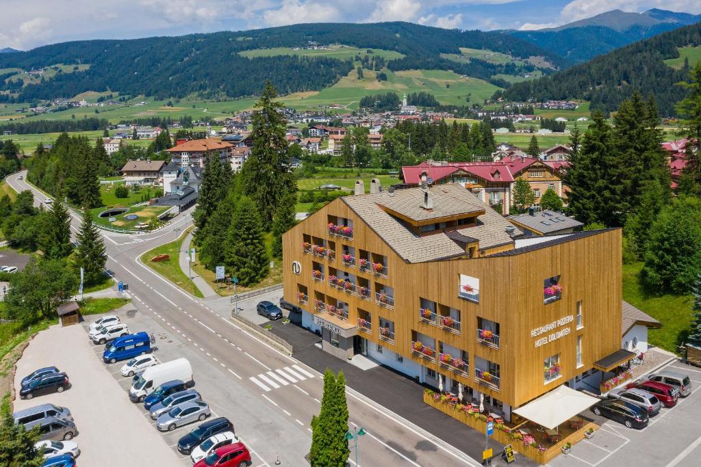 eine Luftansicht eines Gebäudes mit einem Parkplatz in der Unterkunft Hotel Dolomiten in Toblach