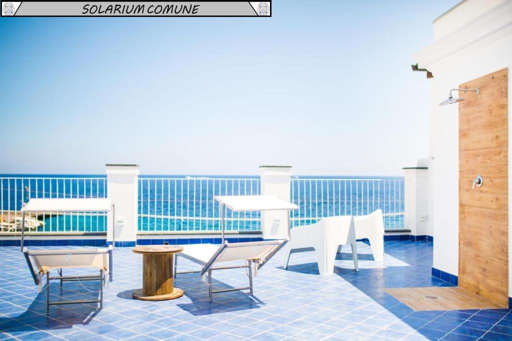 a balcony with chairs and tables on a cruise ship at Zagma Un Passo Dal Mare in Canneto