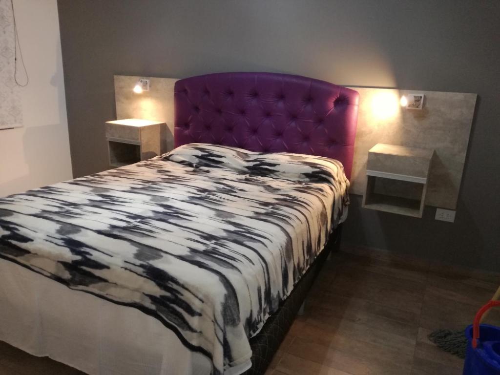 um quarto com uma cama grande e uma cabeceira de cama roxa em Ivon em Neuquén