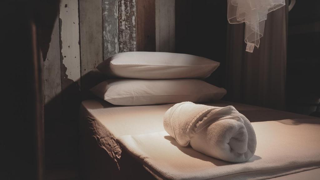 ein Stapel weißer Kissen auf einem Bett in der Unterkunft Frenz Republic - SELF CHECK IN in George Town
