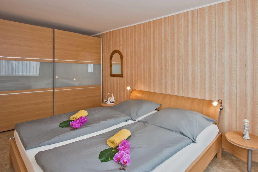 ツィノヴィッツにあるFerienwohnung zur Ostsee 4のベッドルーム1室(花の飾られたベッド1台付)