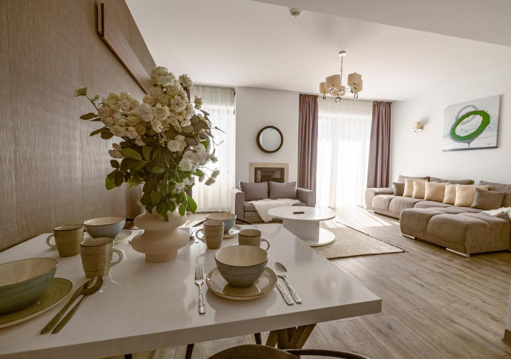 a living room with a table with a vase of flowers at Apartament lux Poiana Brasov B23 in Poiana Brasov