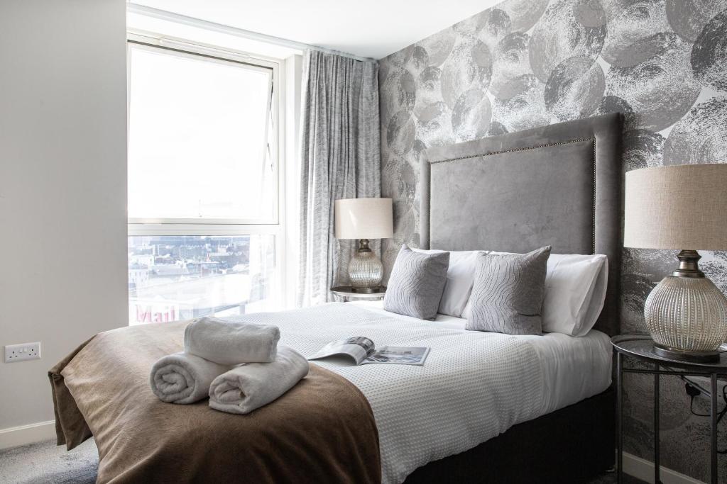 ein Schlafzimmer mit einem großen Bett mit Handtüchern darauf in der Unterkunft Luxury 5* Heart of The City, Fabulous Views in Belfast