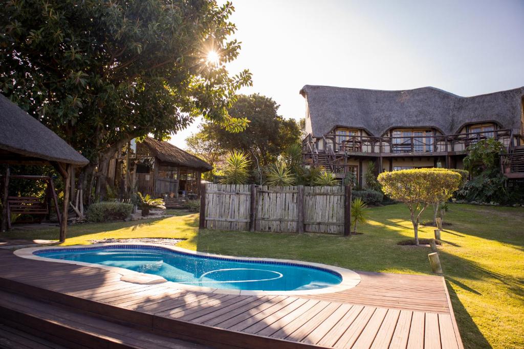 a backyard with a swimming pool and a wooden deck at The Birdhouse Bed & Breakfast #NO Loadshedding #Solar Energy in Gonubie