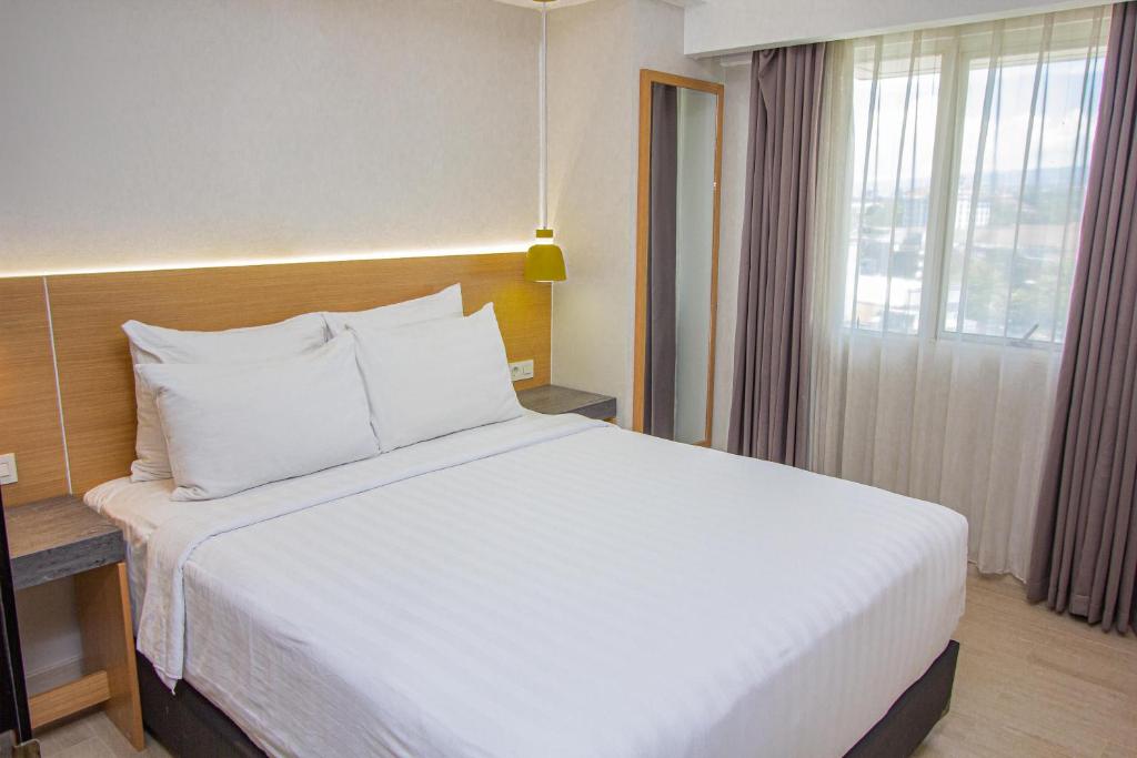 Tempat tidur dalam kamar di Grand Dafam Braga Bandung