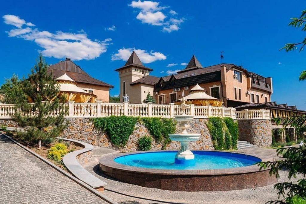 a large house with a fountain in front of a building at Forest club Sherwood in Umanʼ