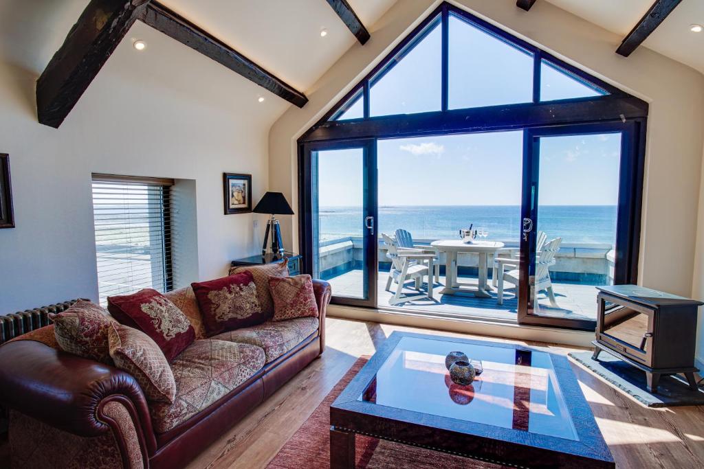 Una sala de estar con un sofá y una mesa y una ventana. en Shore Hotel, en Port Saint Mary