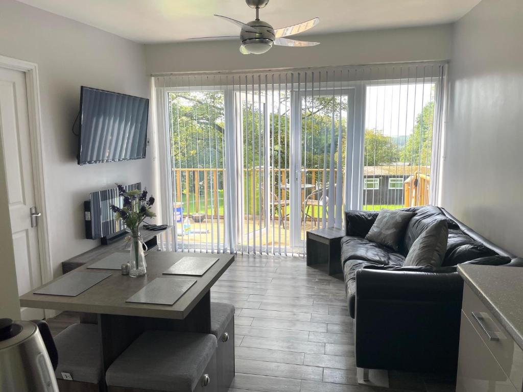 a living room with a couch and a table at JJs Lodge Holiday Home Bude in Kilkhampton