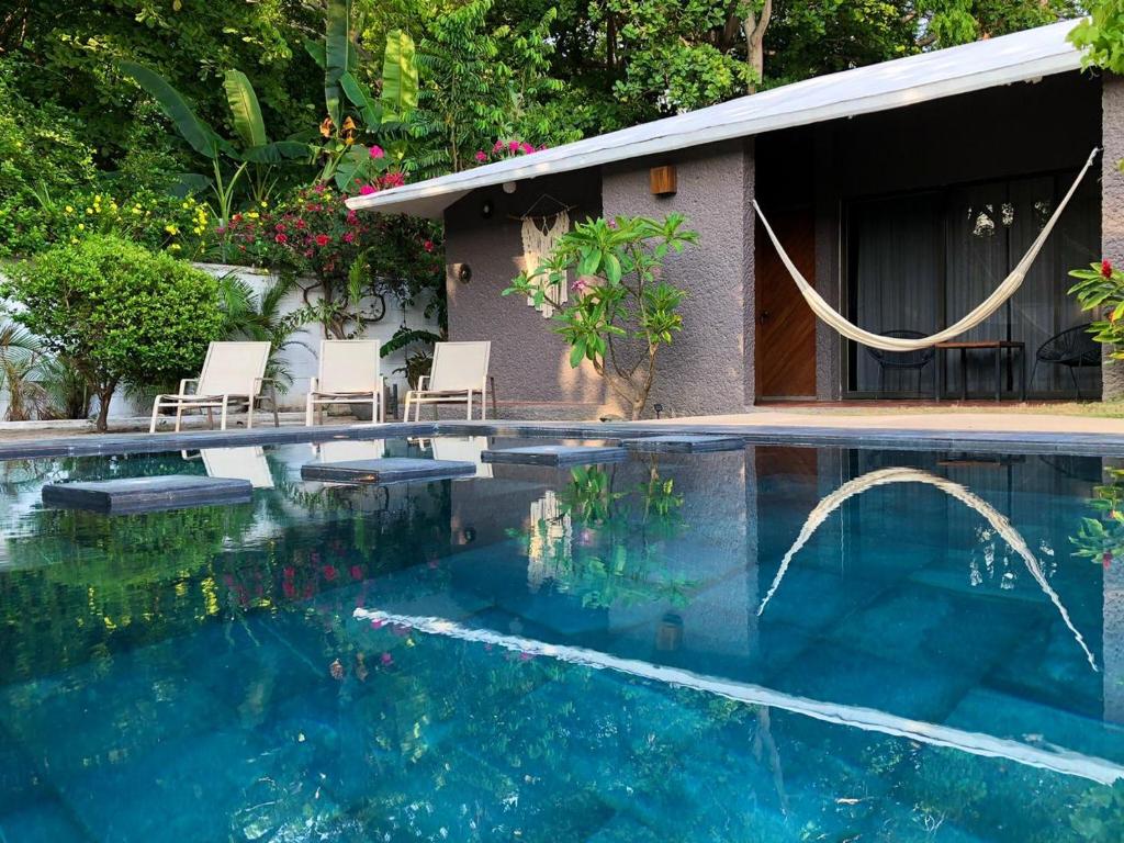 una piscina con sedie e una casa di Casa Sirena a Ixtapa