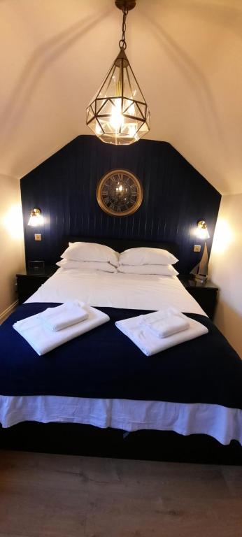 a bedroom with a large bed with two towels on it at The Old Schoolhouse in Whitstable