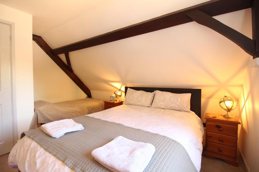 a bedroom with a large bed with two towels on it at The Old Schoolhouse in Whitstable