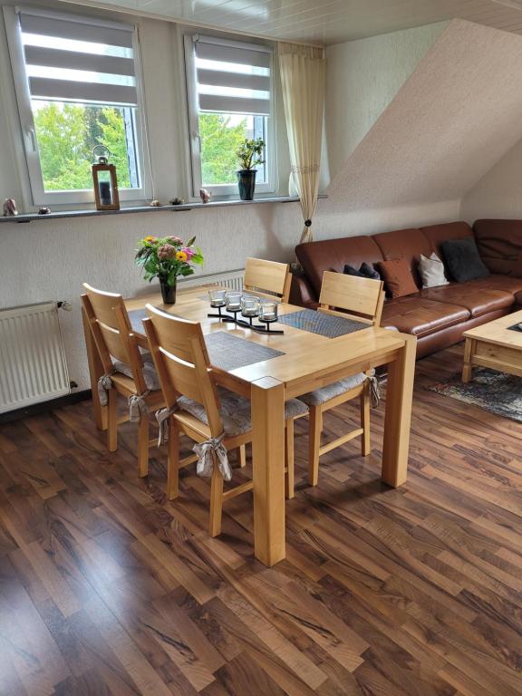 ein Wohnzimmer mit einem Holztisch und Stühlen in der Unterkunft Apartment Bergisches Land in Wermelskirchen