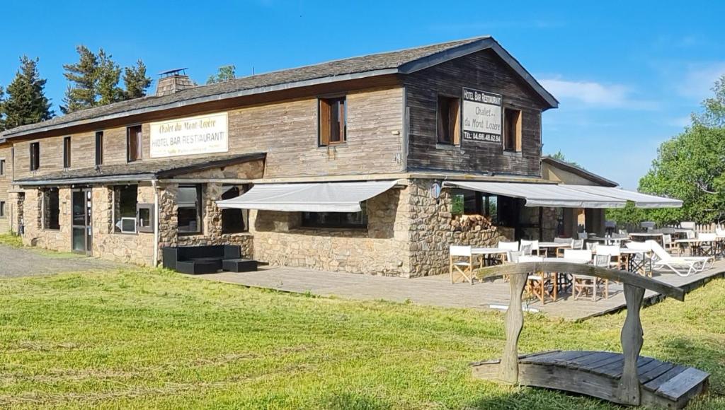 un bâtiment avec un banc devant lui dans l'établissement Chalet du Mont Lozère, à Cubières