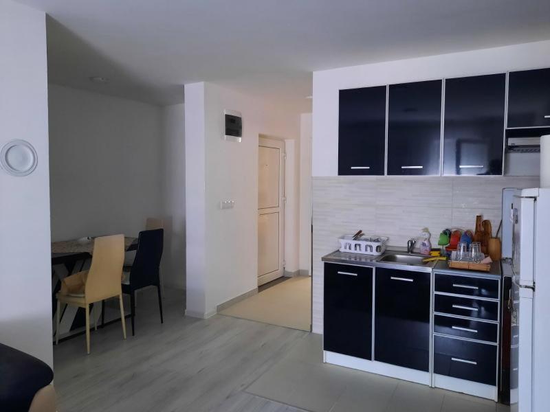 a kitchen with black cabinets and a table in a room at Apartman Centar Novi Grad in Bosanski Novi