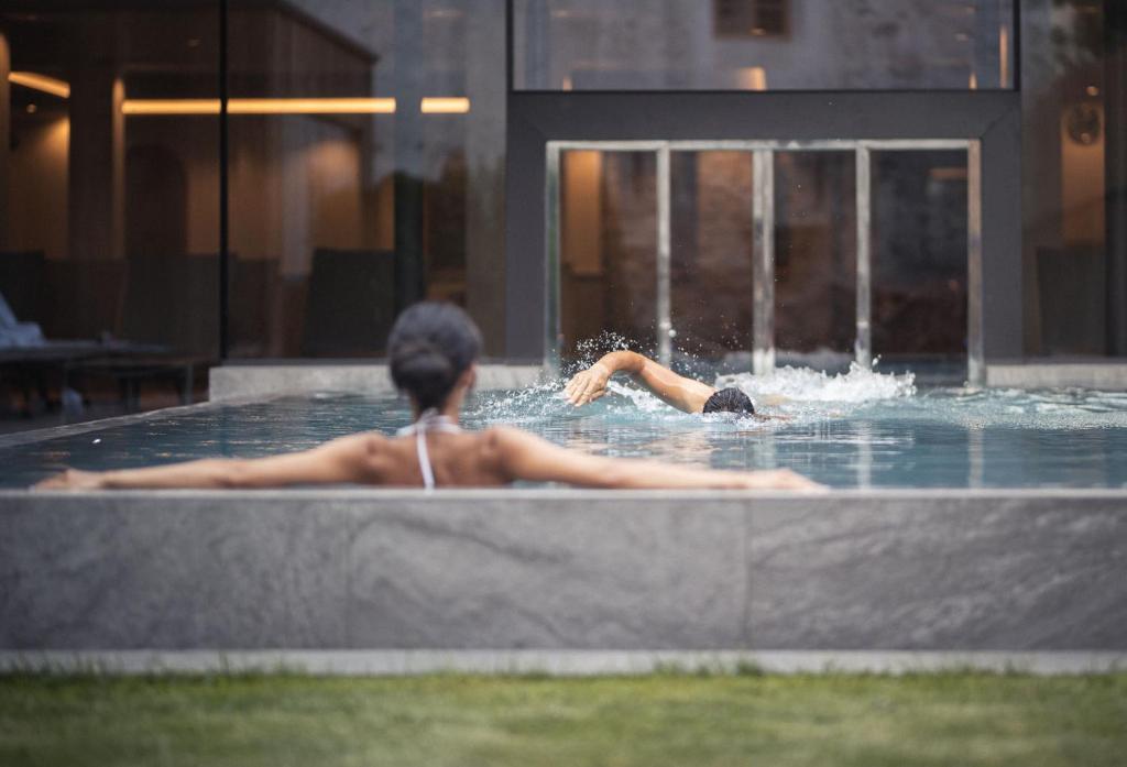 une femme se baignant dans une piscine dans un bâtiment dans l'établissement Autentis, à Rasùn di Sotto