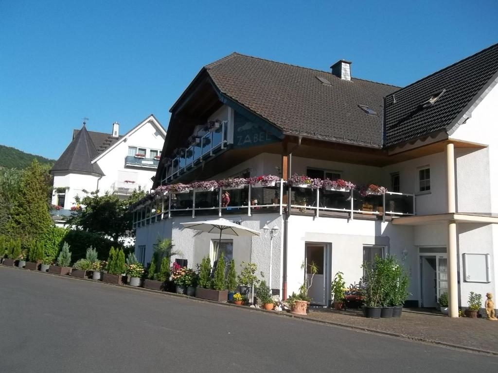 biały dom z kwiatami na balkonach w obiekcie Ferienhaus Zabel w mieście Bruttig-Fankel