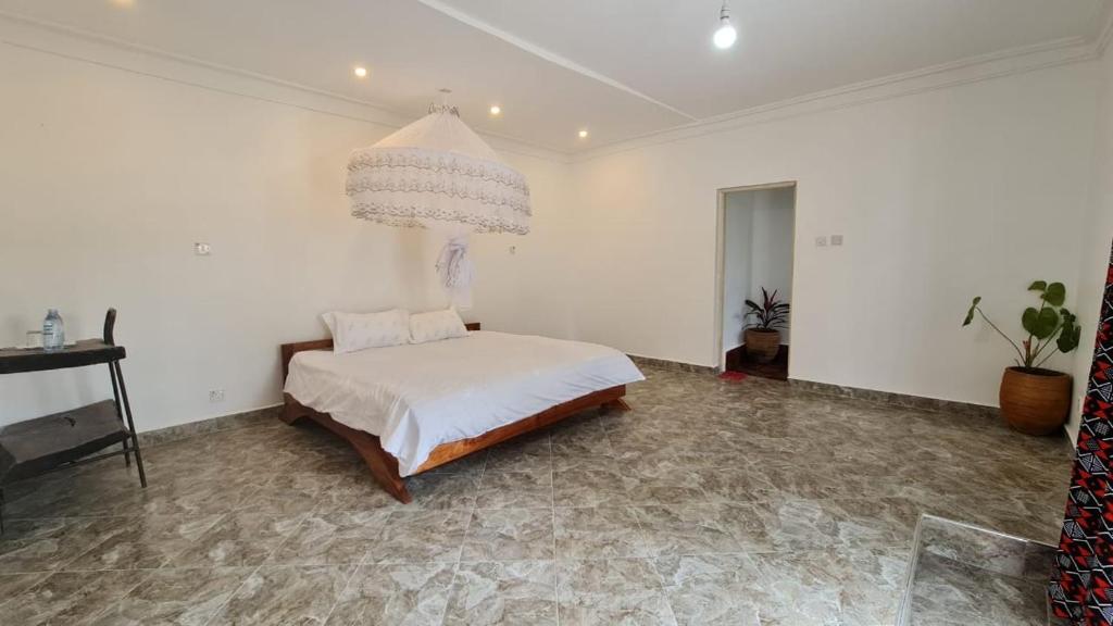 Schlafzimmer mit einem Bett und einem Kronleuchter in der Unterkunft GKAT Resort in Mbarara