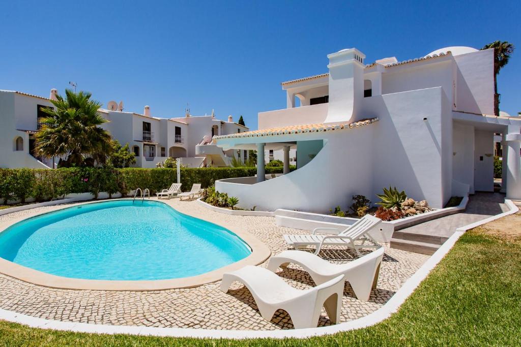 a villa with a swimming pool in front of a house at Casa São Rafael by LovelyStay in Albufeira
