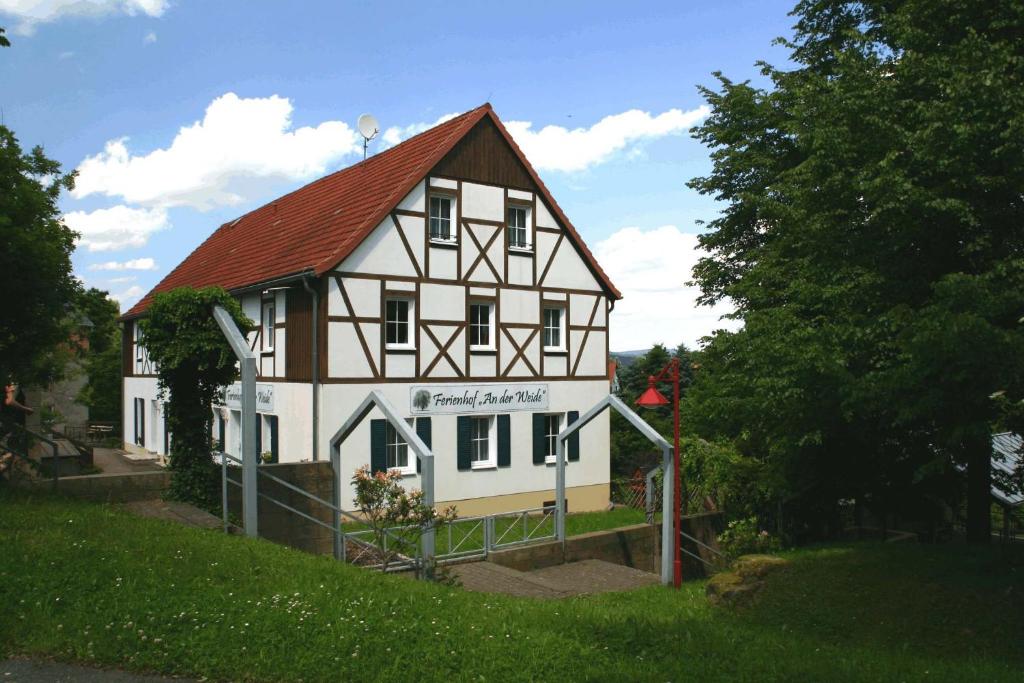 a large white building with a red roof at Ferienhof An der Weide in Kurort Gohrisch