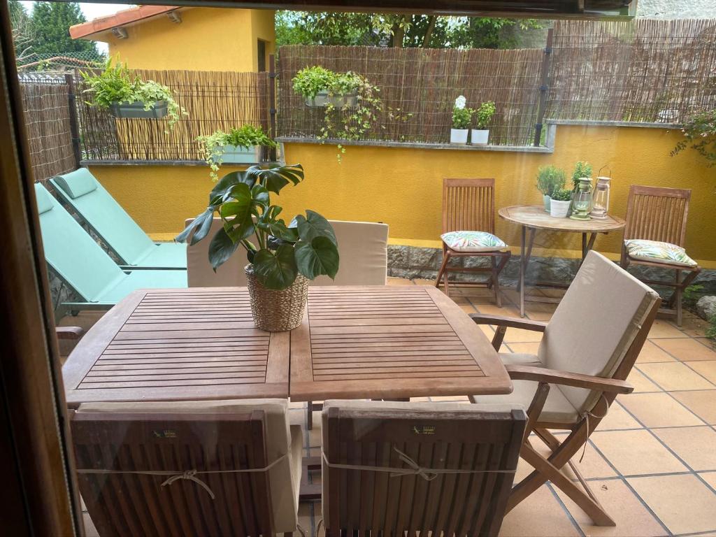 una mesa de madera con una maceta en el patio en Casa Poo de Llanes con jardín, en Póo