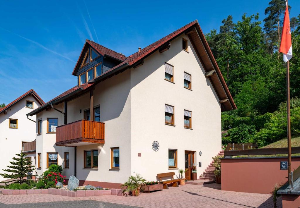 un grand bâtiment blanc avec un toit marron dans l'établissement Ferienwohnung Hauk, à Laudenbach