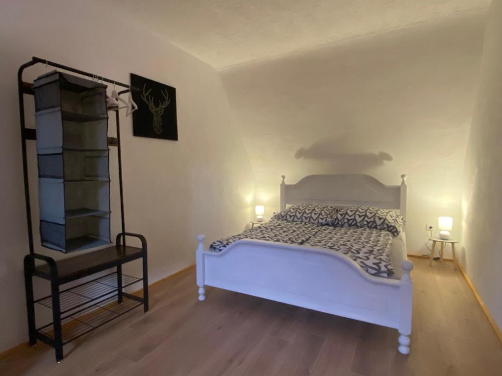 a bedroom with a white bed and a shelf at FeWo Weisweil in Weisweil