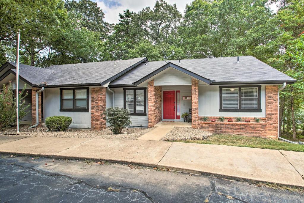 a brick house with a red door at Hot Springs House with Spacious Deck and Grill! in Hot Springs Village