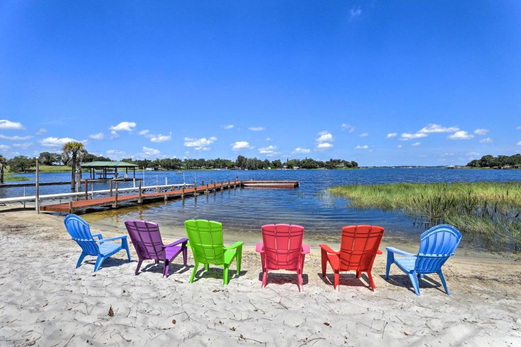 a group of colorful chairs sitting on the beach at Lakefront Babson Park Escape: Pet Friendly! in Frostproof