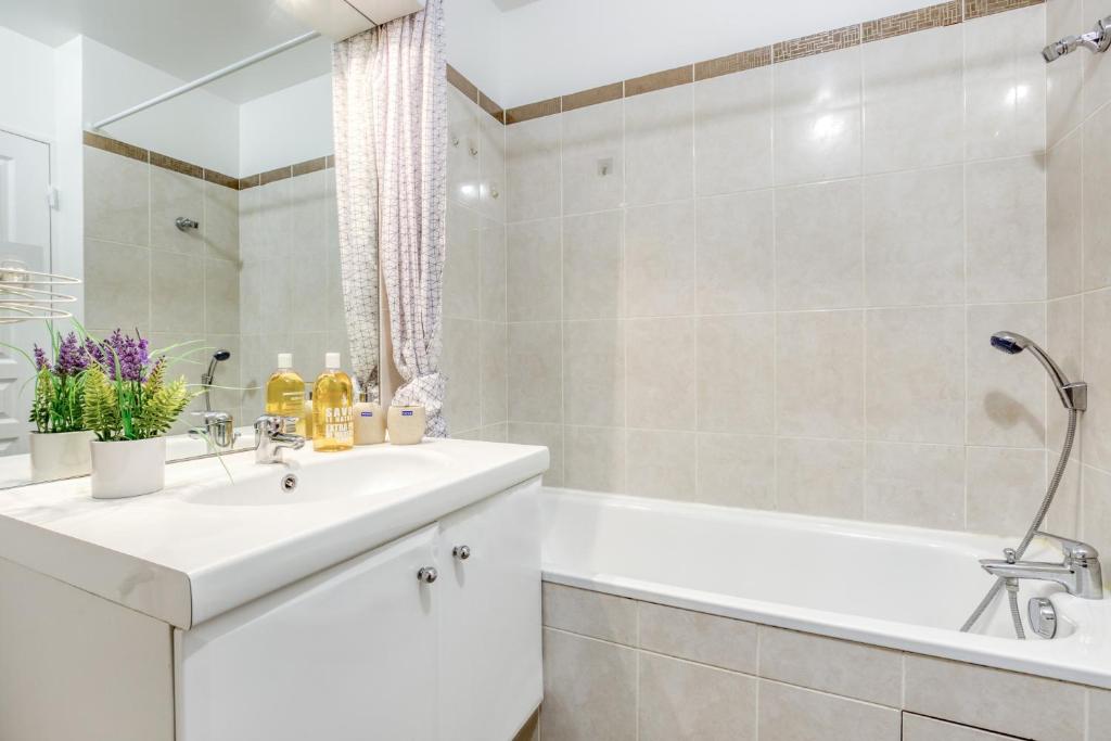 a white bathroom with a tub and a sink and a bath tub at DÉPLACEMENT PRO &amp; TOURISME - NETFLIX - WIFI - Easy CHECK-IN in Bourg-la-Reine