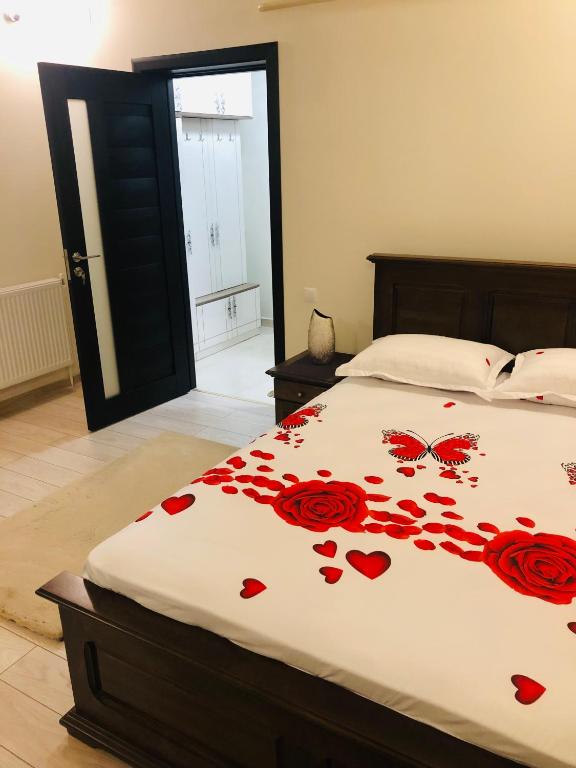 a bedroom with a bed with red roses on it at APARTAMENT PARK in Brăila