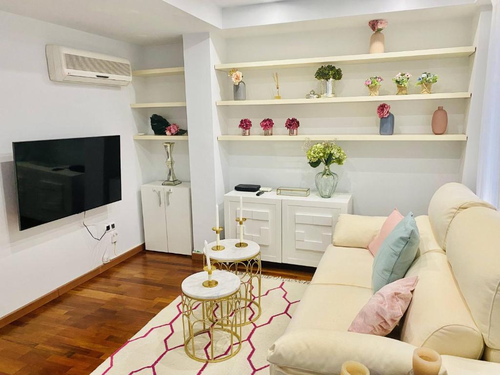 ein Wohnzimmer mit einem Sofa und einem TV in der Unterkunft Apartamento Plaza España in Saragossa