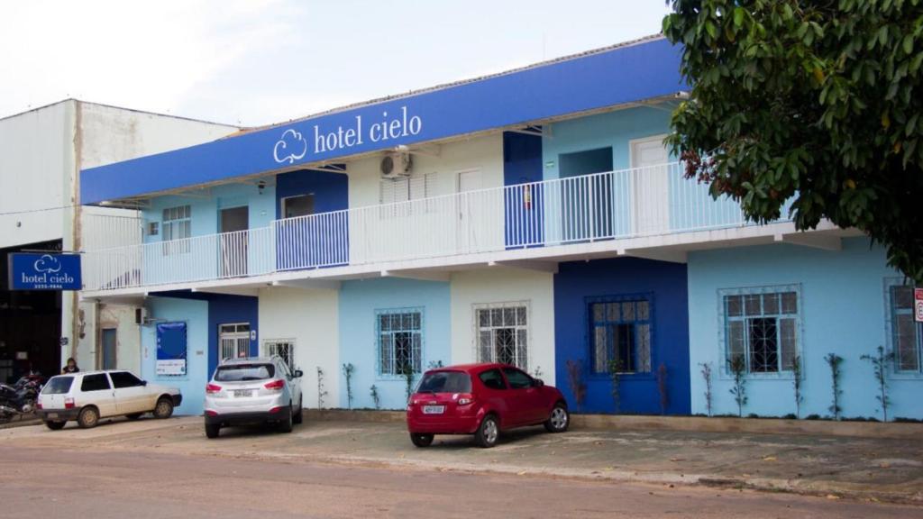 un edificio azul con coches estacionados frente a él en Hotel Cielo, en Porto Velho