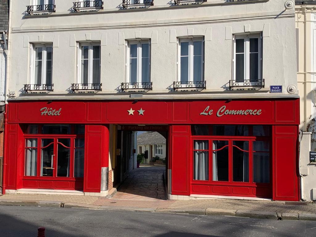 una tienda roja frente a un edificio en Hôtel Du Commerce en Fécamp