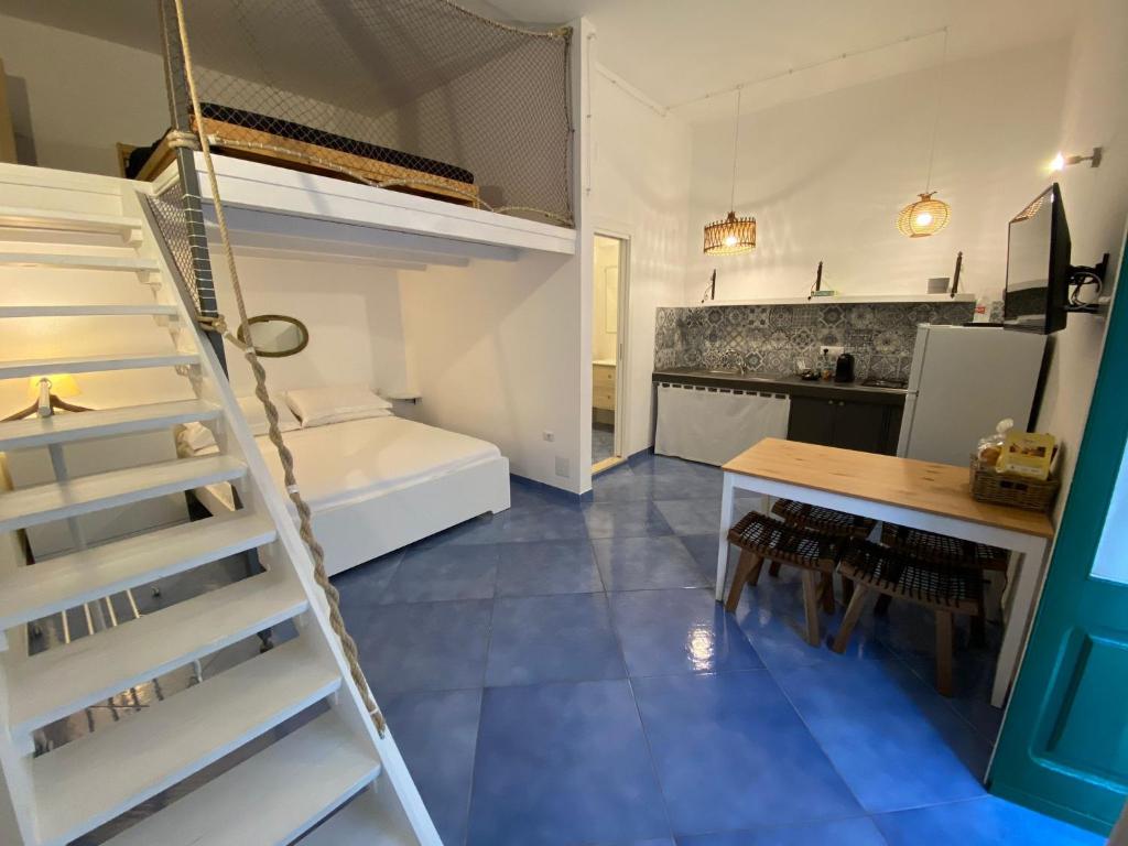 a room with a ladder and a kitchen with a bunk bed at B&B LA CASA DEL PESCATORE in Marina di Camerota
