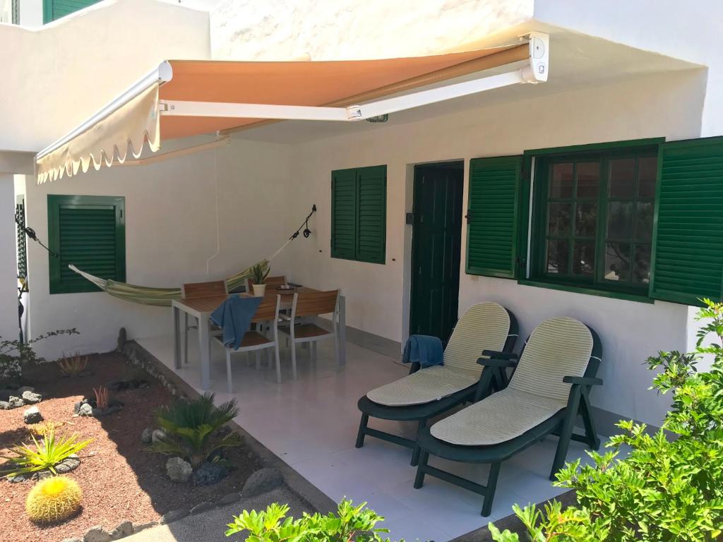 a patio with chairs and a table and a hammock at Apartamento La Piedra DIRECTO en Playa in La Oliva