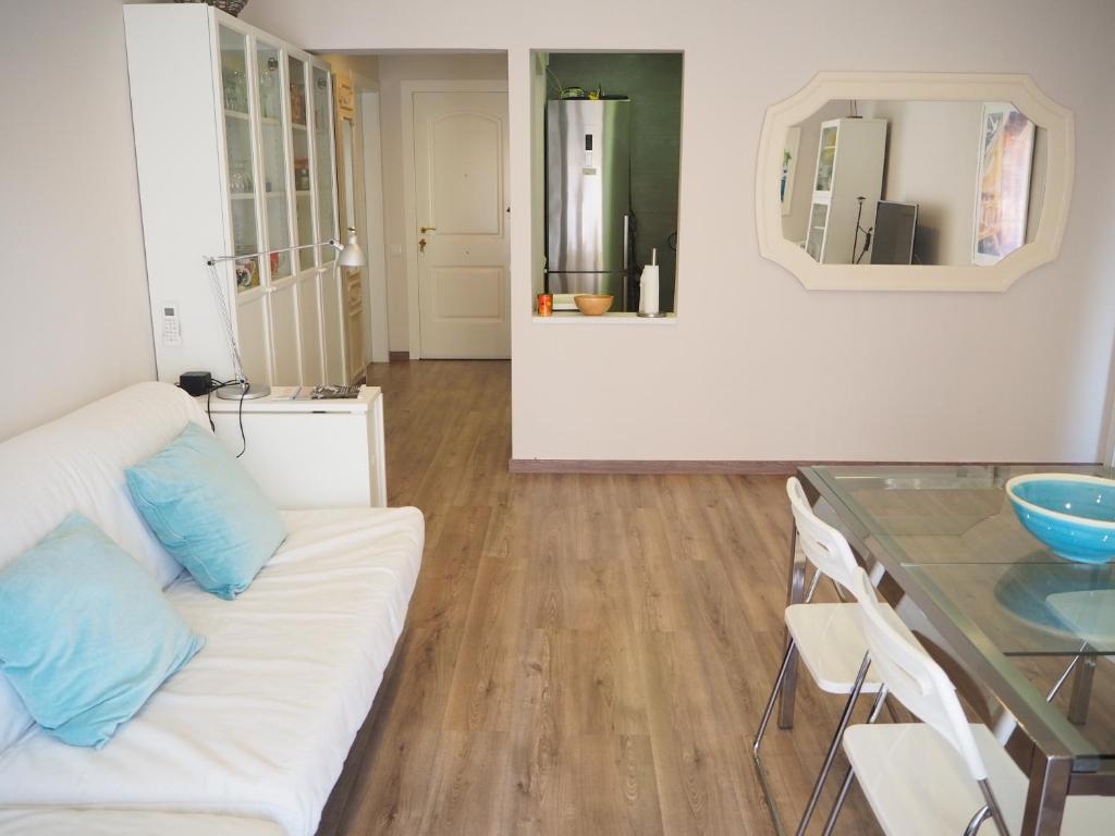 a living room with a white couch and a table at Apartament per families a Sant Feliu amb piscina in Sant Feliu de Guixols