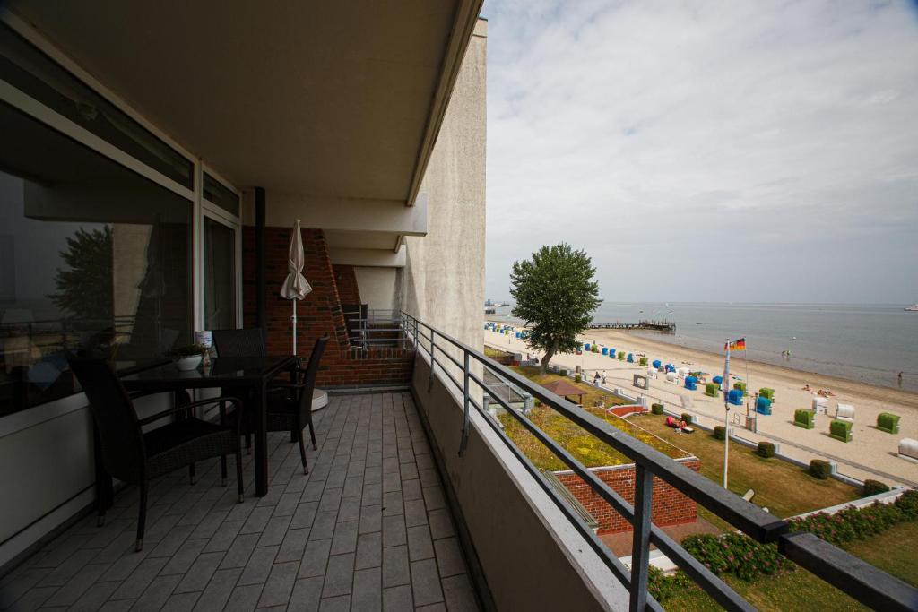 balcón con mesa y sillas y vistas a la playa en Klaar Kimming, en Großenaspe