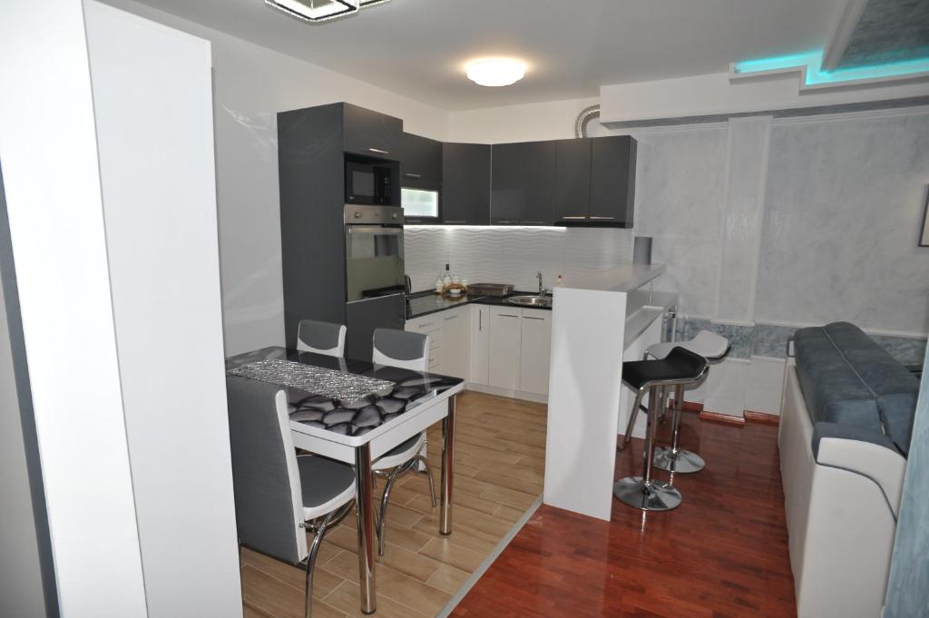 a kitchen with a table and chairs in a room at Twins Apartments in Čačak