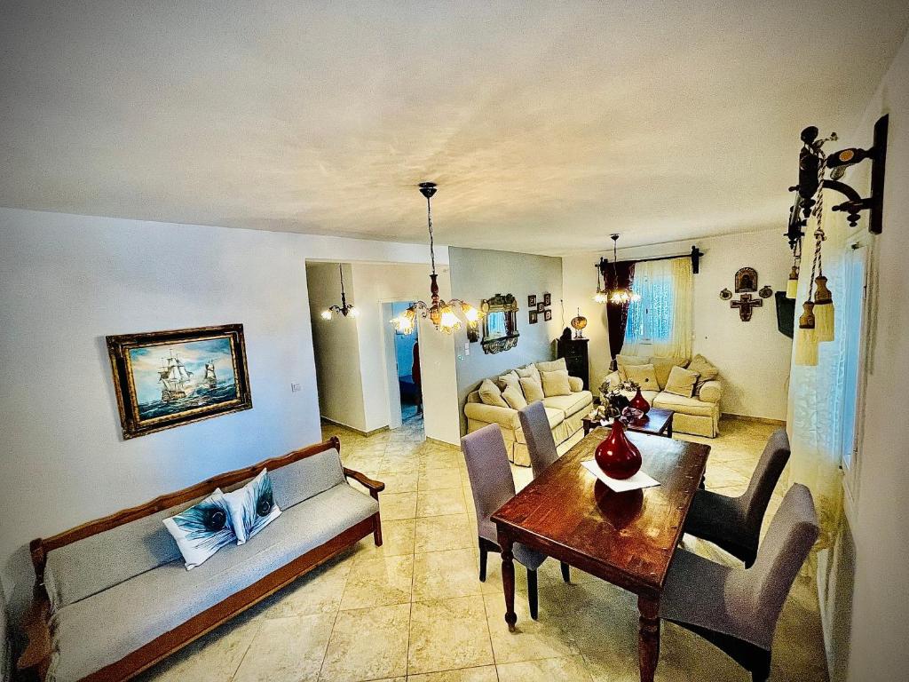 a living room with couches and a dining table at Villa Arietta Santorini in Perissa