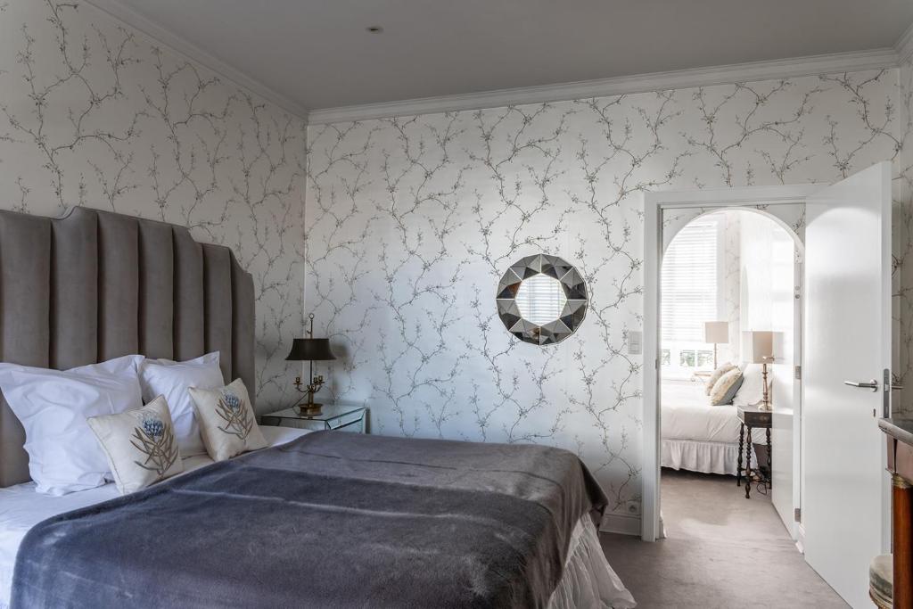 a bedroom with a bed and a mirror on the wall at Molenmeers Boutique Guesthouses in Bruges