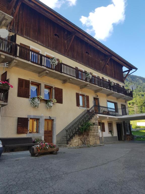 un gran edificio con balcones y flores delante de él en Gîte de la snaille en Le Reposoir