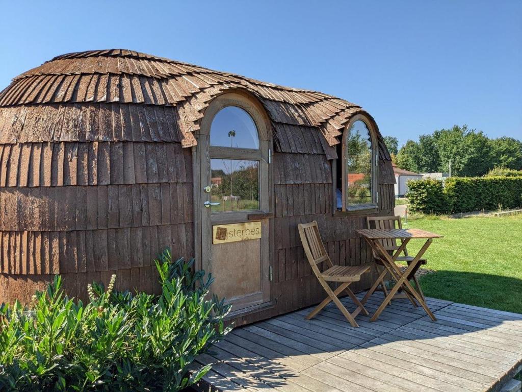 une yourte avec 2 chaises et une table sur une terrasse dans l'établissement Camping Houtum, à Kasterlee