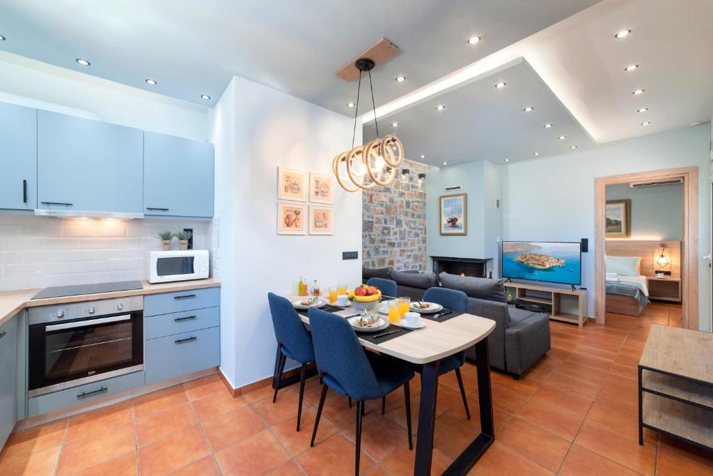 伊羅達的住宿－Casa Kaneli Luxury Villa Elounda，厨房以及带桌椅的起居室。