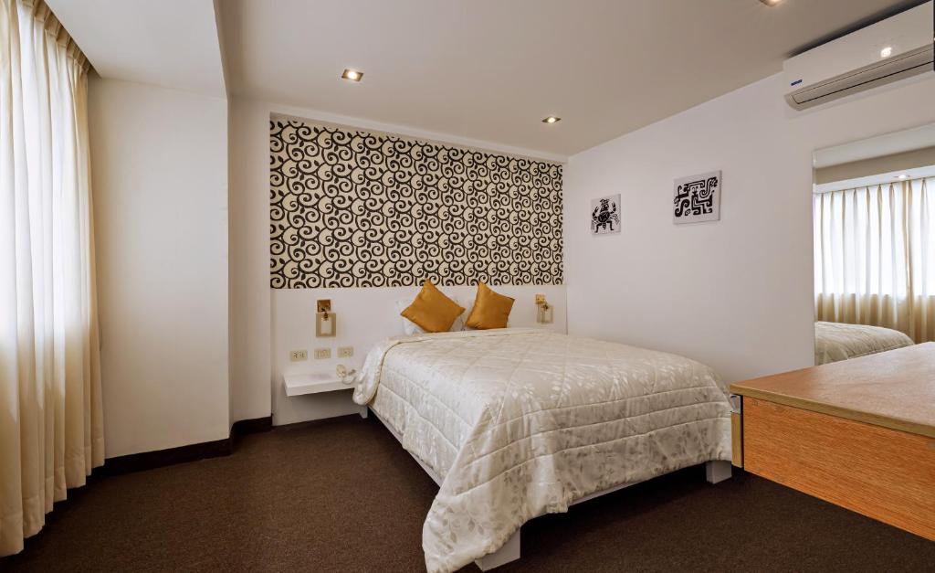 sypialnia z łóżkiem i ścianą w obiekcie Hotel Médano w mieście Trujillo