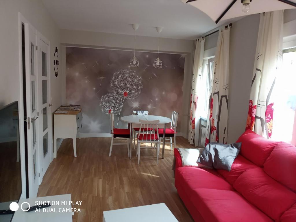 a living room with a red couch and a table at EL RAMILLETE in Soria