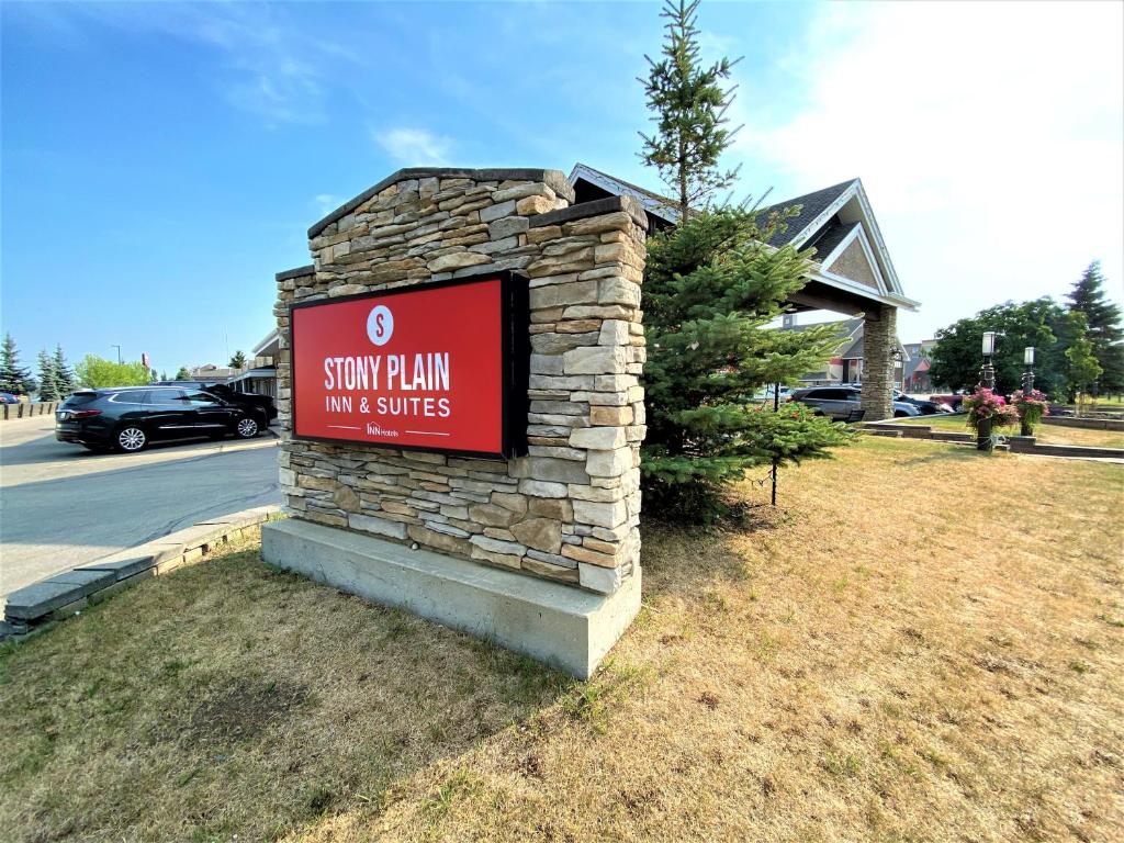 un panneau indiquant une auberge de ski avec un bâtiment dans l'établissement Stony Plain Inn & Suites, à Stony Plain